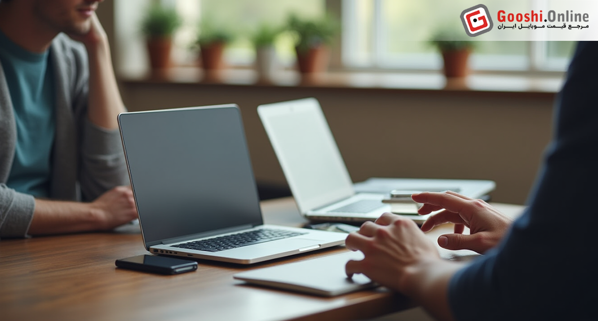 یک شخص درحال مقایسه دو لپ‌تاپ برای خرید لپ تاپ