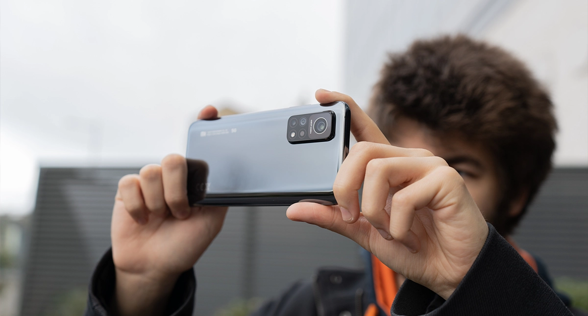یک شخص درحال عکاسی با یک گوشی میان‌رده شیائومی