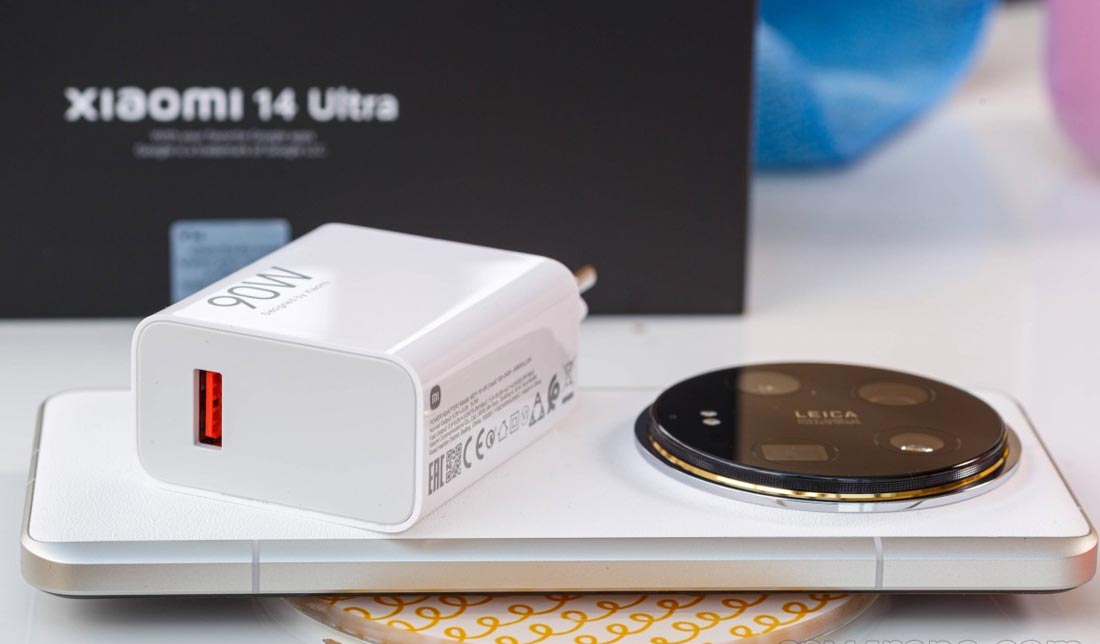 گوشی ‏Xiaomi 14 Ultra به همراه آداپتور 90 وات بر روی آن