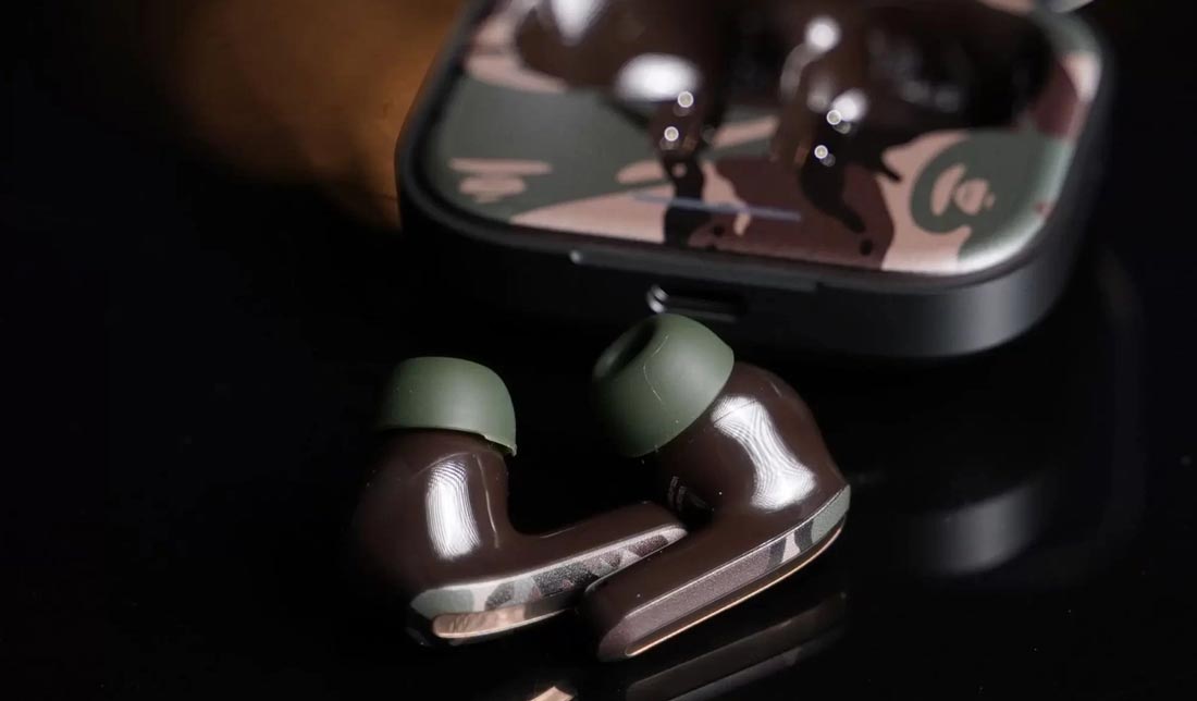 ردمی بادز 5 ‏AAPE به همراه کیس بر روی میز