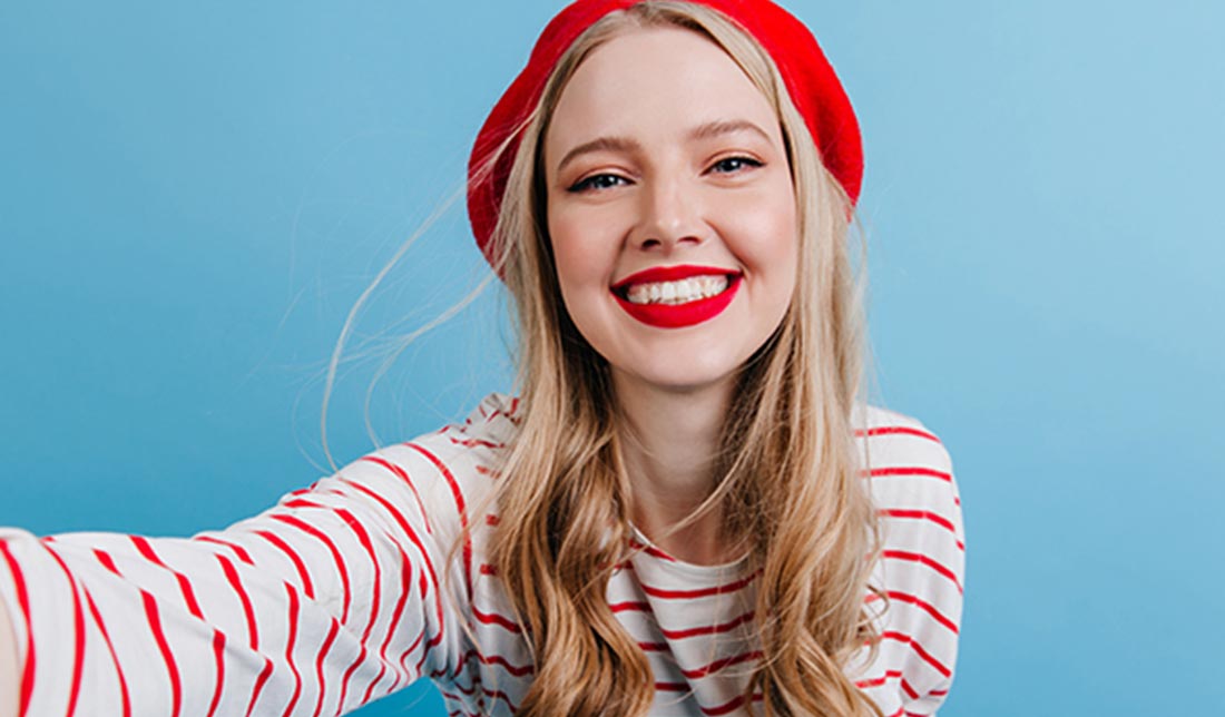 نمونه‌ای از یک عکس سلفی از دختری درحال لبخند زدن در پس‌زمینه آبی